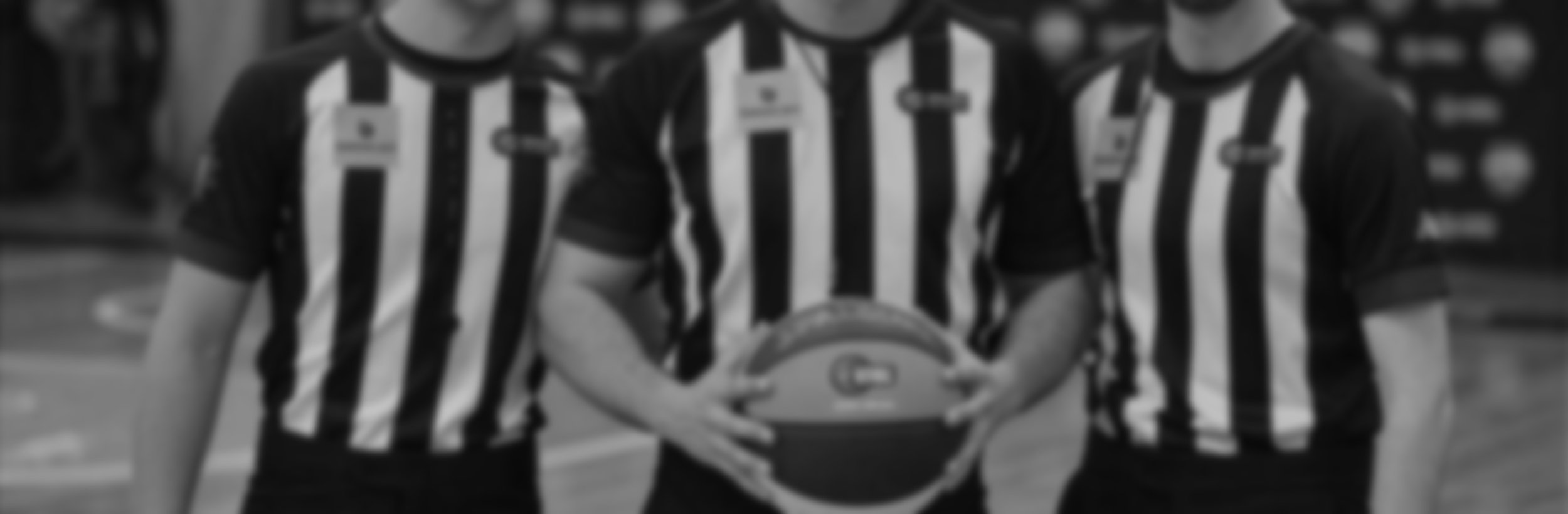 Referees on court in black and white